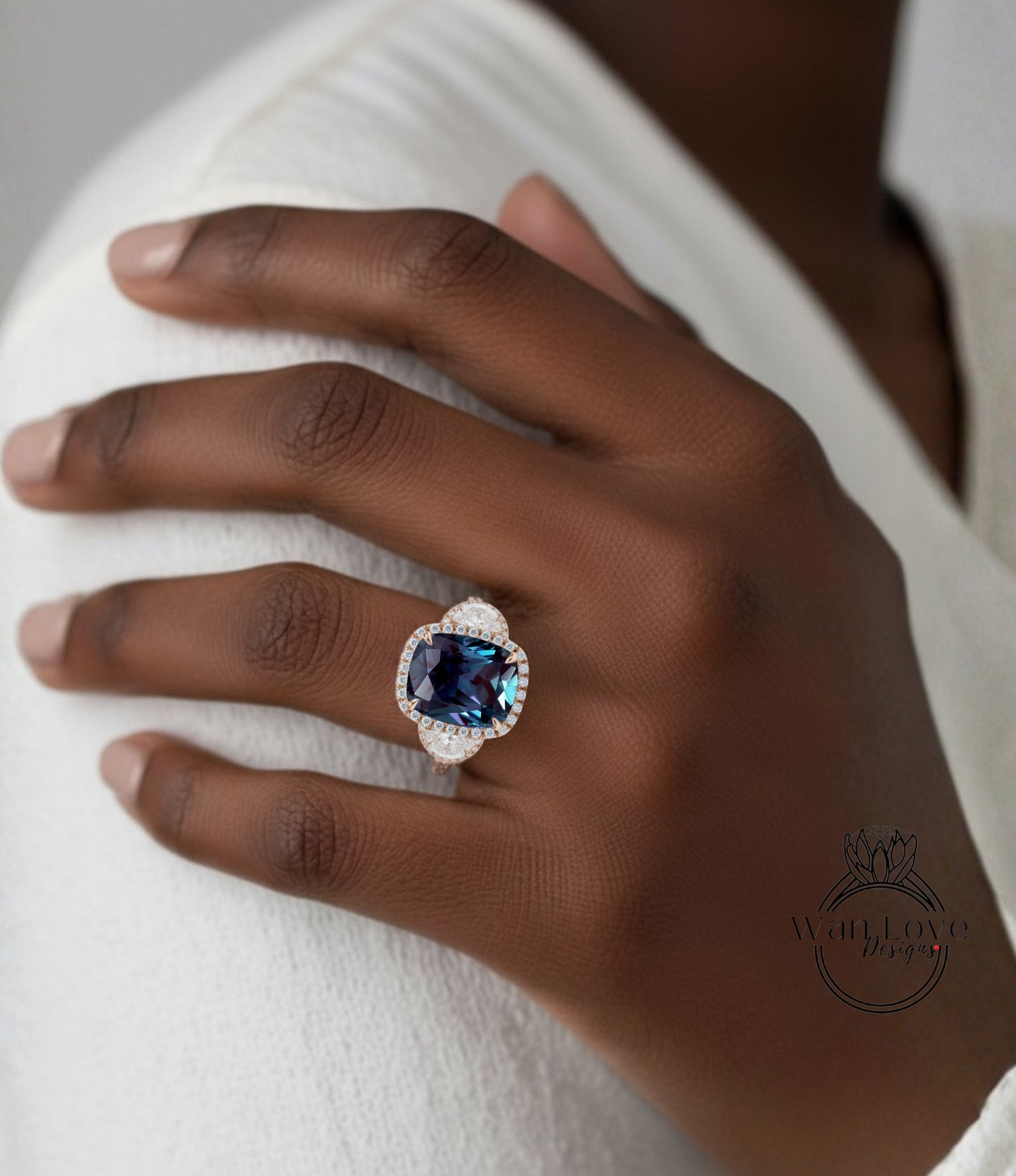 A close-up of a hand wearing a ring with a large blue gemstone.