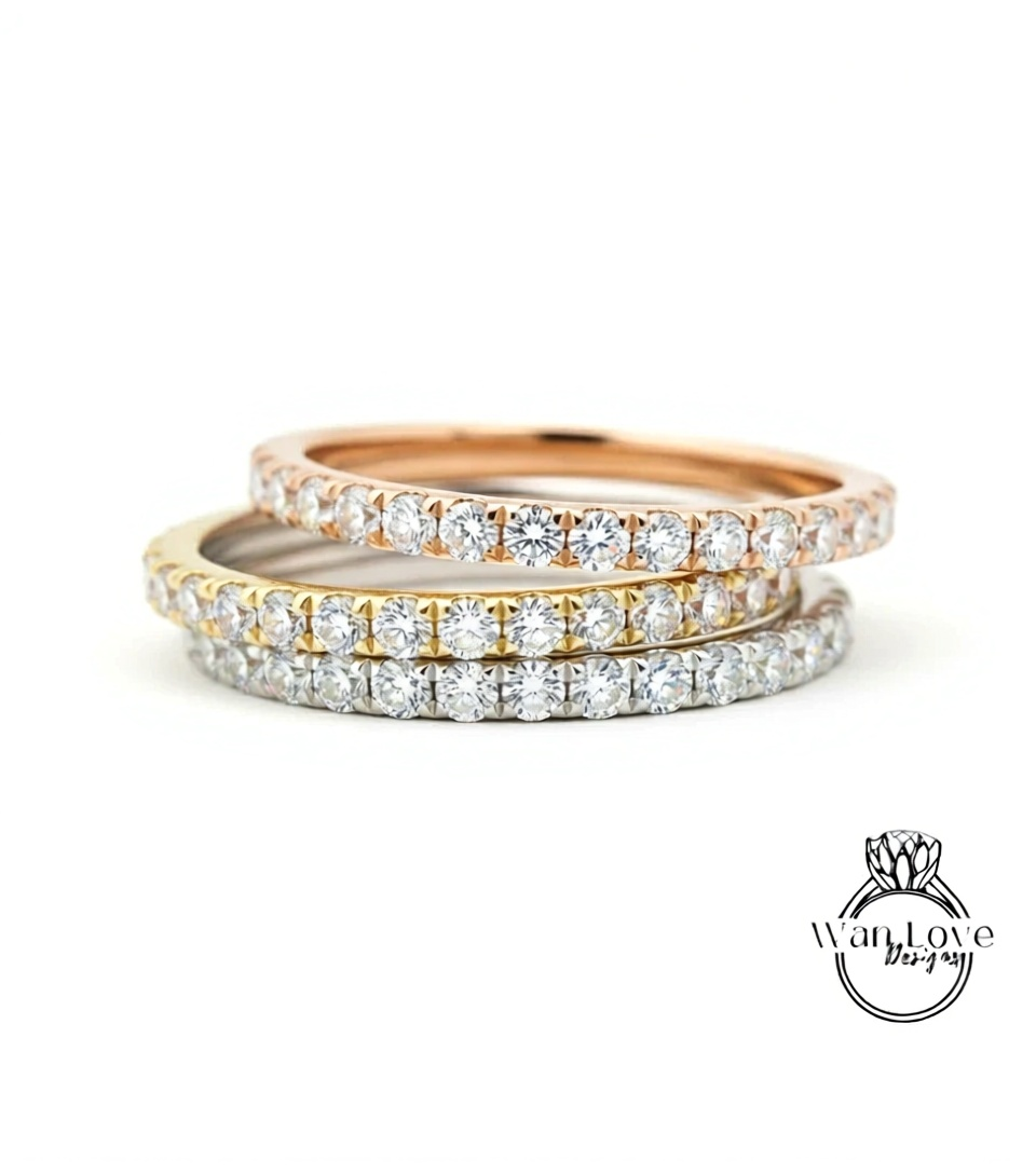 A close-up view of a stack of three rings, each adorned with a row of diamonds.