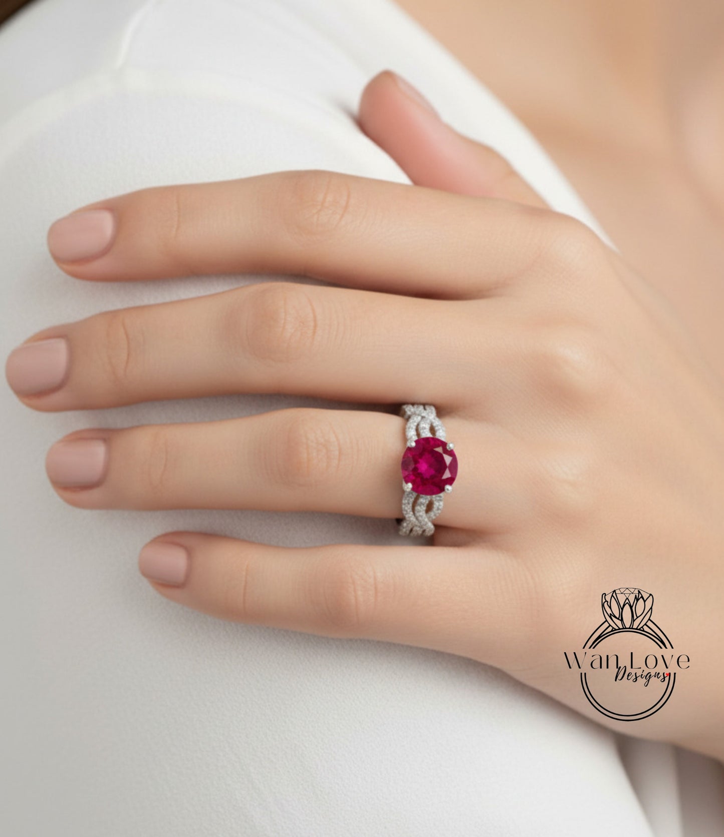 A close-up of a person's hand wearing a ring with a large, vibrant red gemstone.