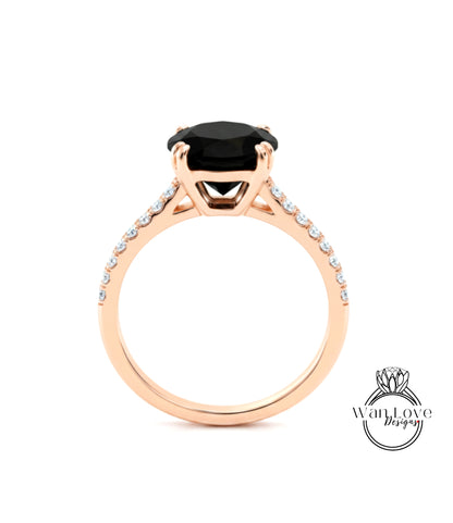A gold ring with a large black gemstone, likely a diamond, set in the center.