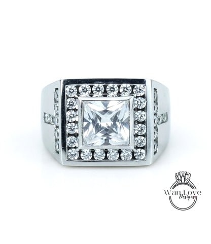 A silver ring with a large, square-cut diamond as the centerpiece, surrounded by smaller diamonds.