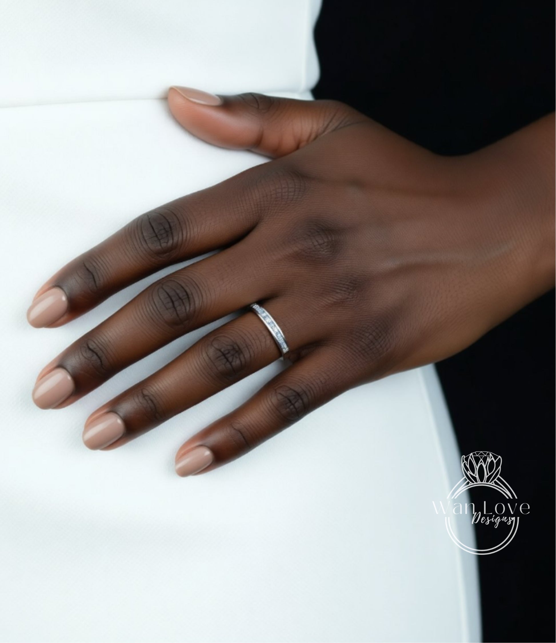 A close-up of a hand wearing a ring on the ring finger.