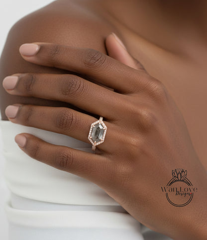 A close-up of a hand wearing a diamond ring on the ring finger.