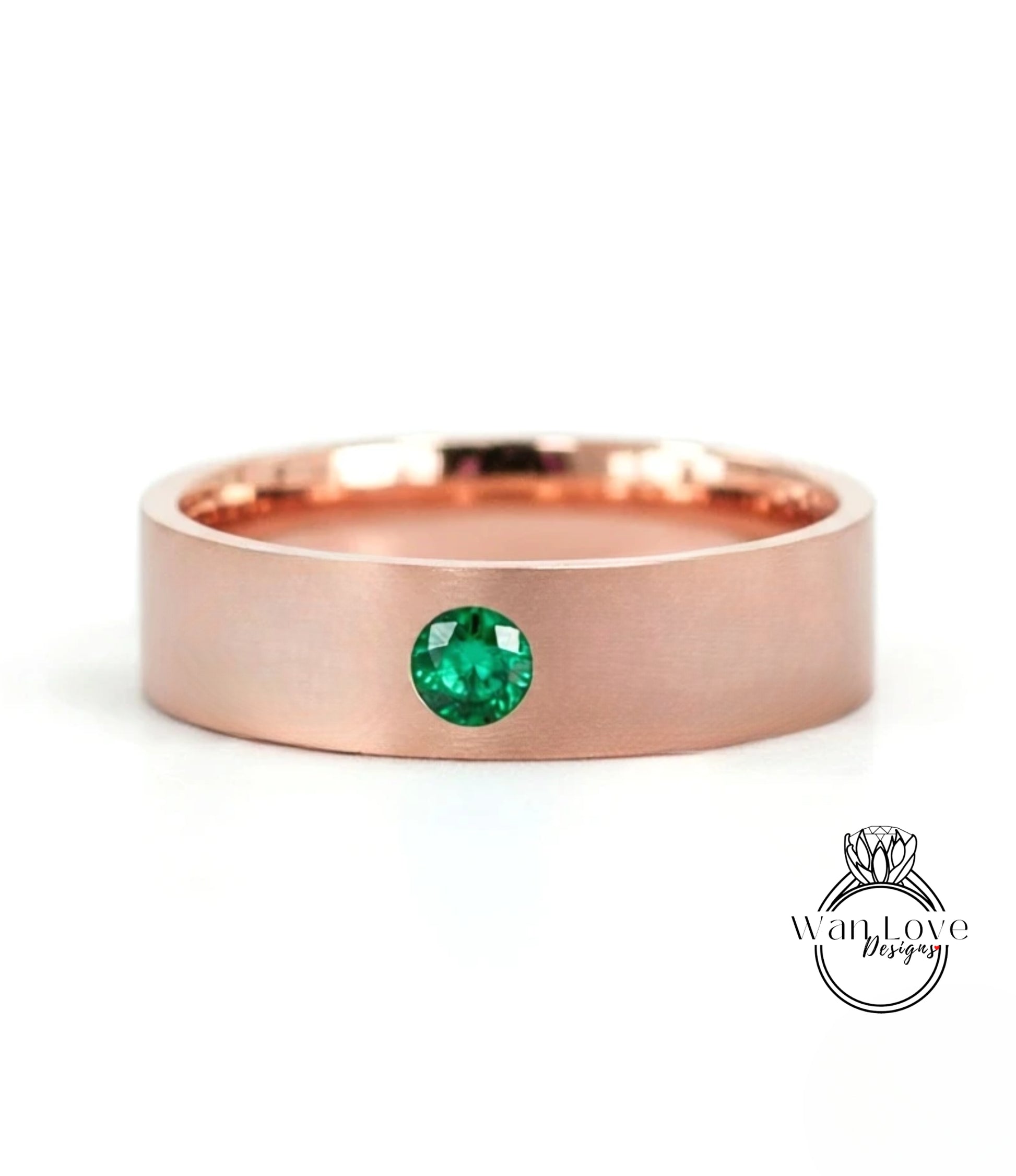 A rose gold ring with a large green gemstone set in the center.