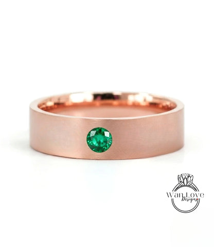 A rose gold ring with a large green gemstone set in the center.