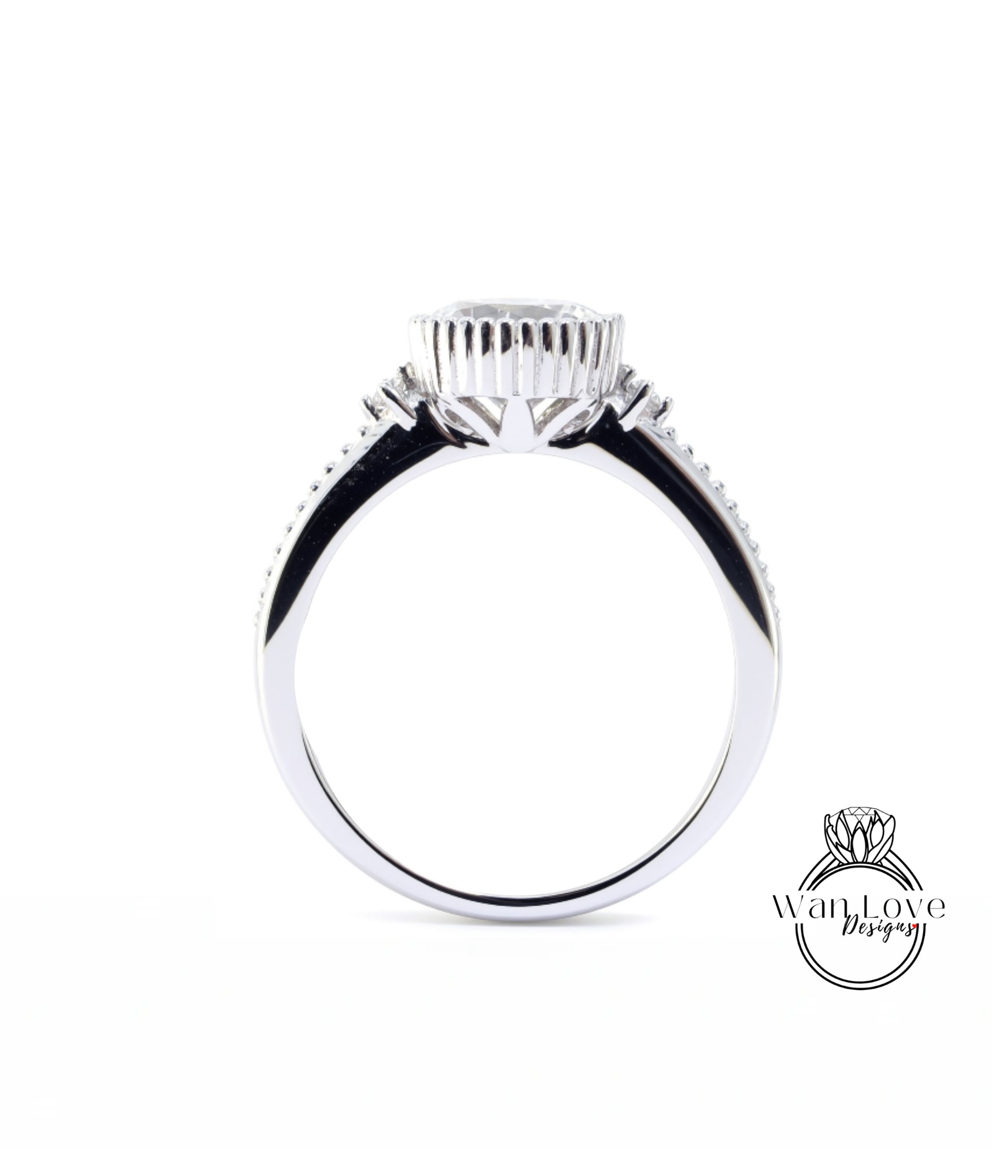 A silver ring with a large central stone and smaller stones on either side.