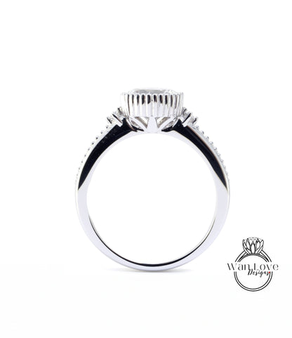 A silver ring with a large central stone and smaller stones on either side.