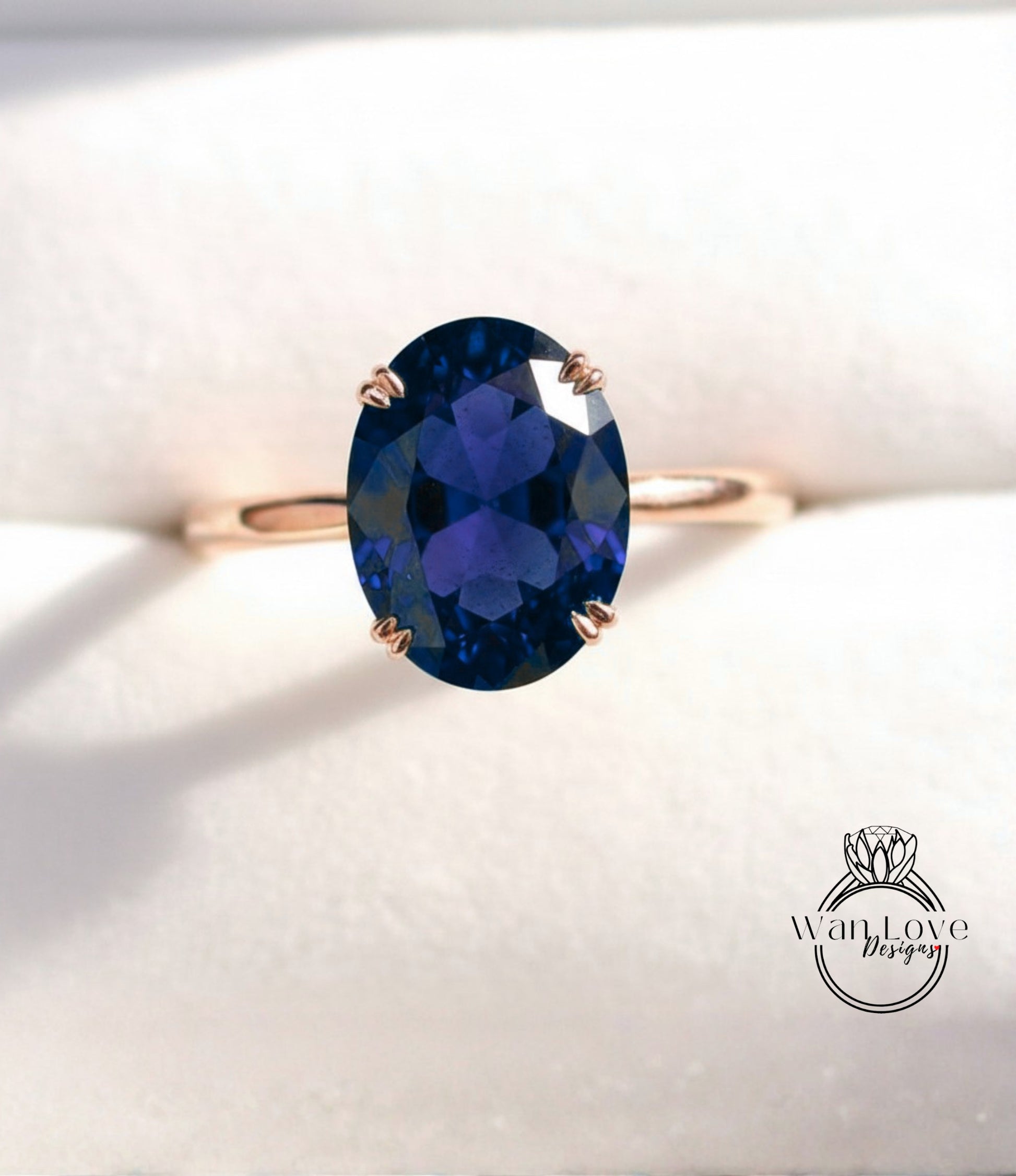 A gold ring with a large oval-shaped blue gemstone, likely a sapphire, set in the center of the band.