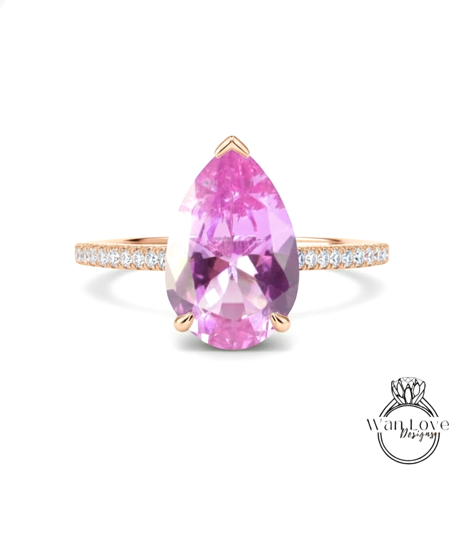 A pink gemstone ring with a gold band and small diamonds.