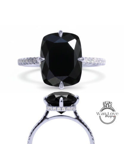 A large, black diamond engagement ring with a silver band and small diamonds.