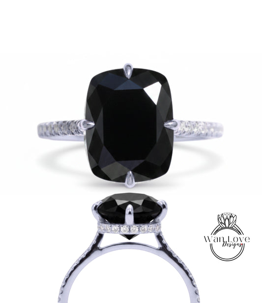 A large, black diamond engagement ring with a silver band and small diamonds.