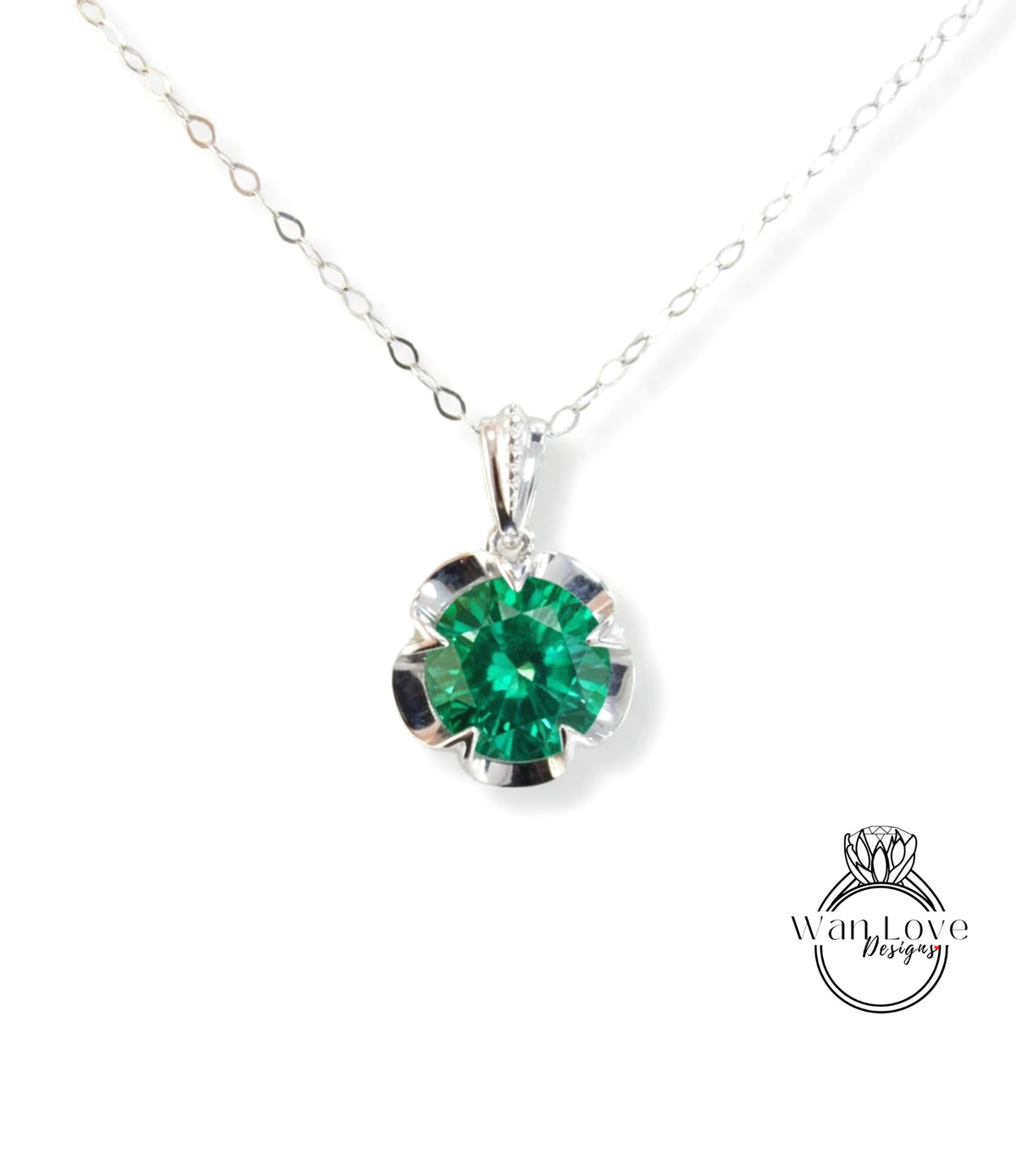 A silver necklace with a large, green gemstone pendant.