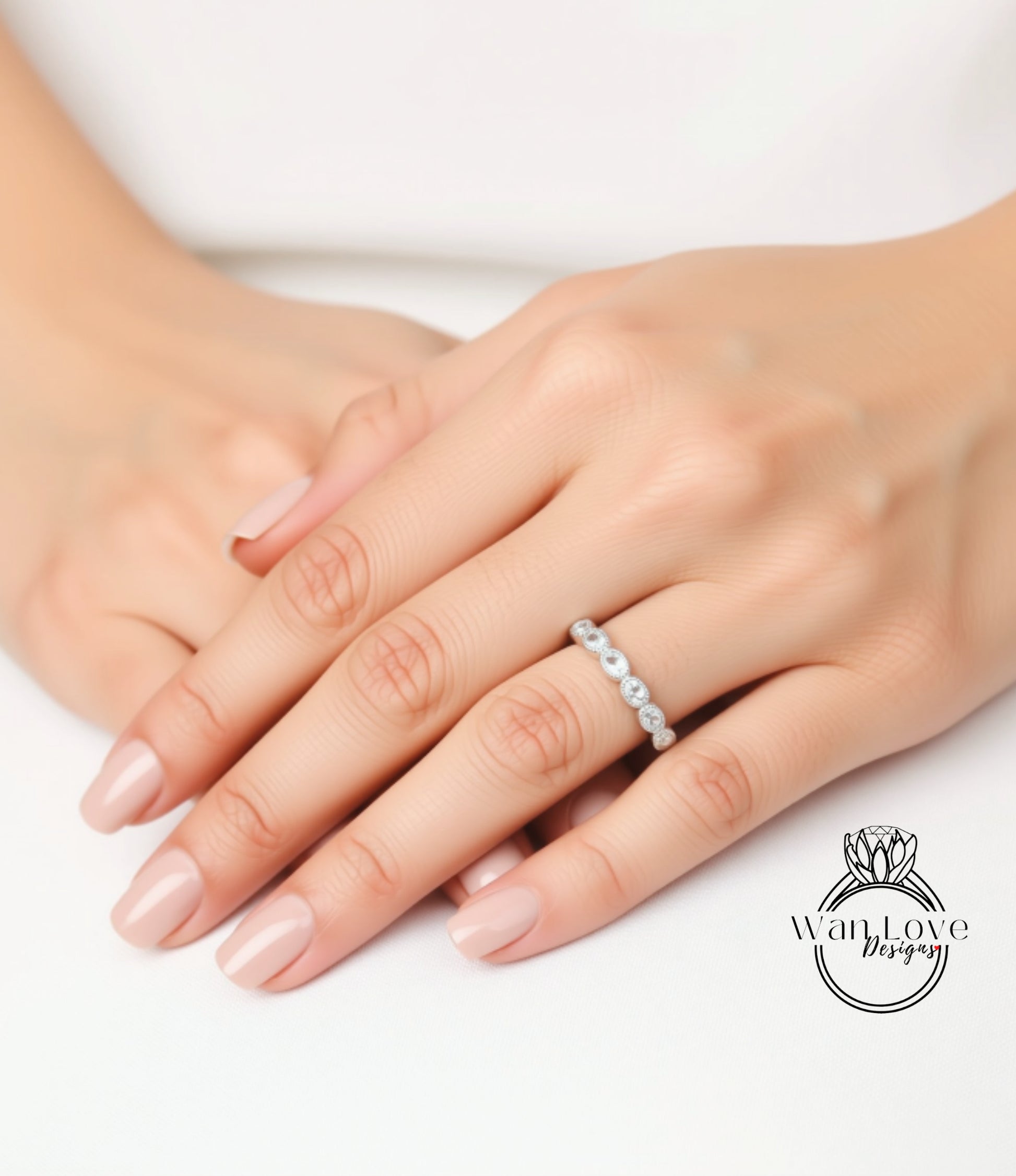 A close-up image of a person's hands wearing a diamond ring on the ring finger.