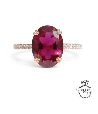 A pink gemstone ring with a large oval-shaped gemstone set in a gold band.