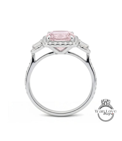 A silver ring with a large pink gemstone, possibly a diamond, set in the center.