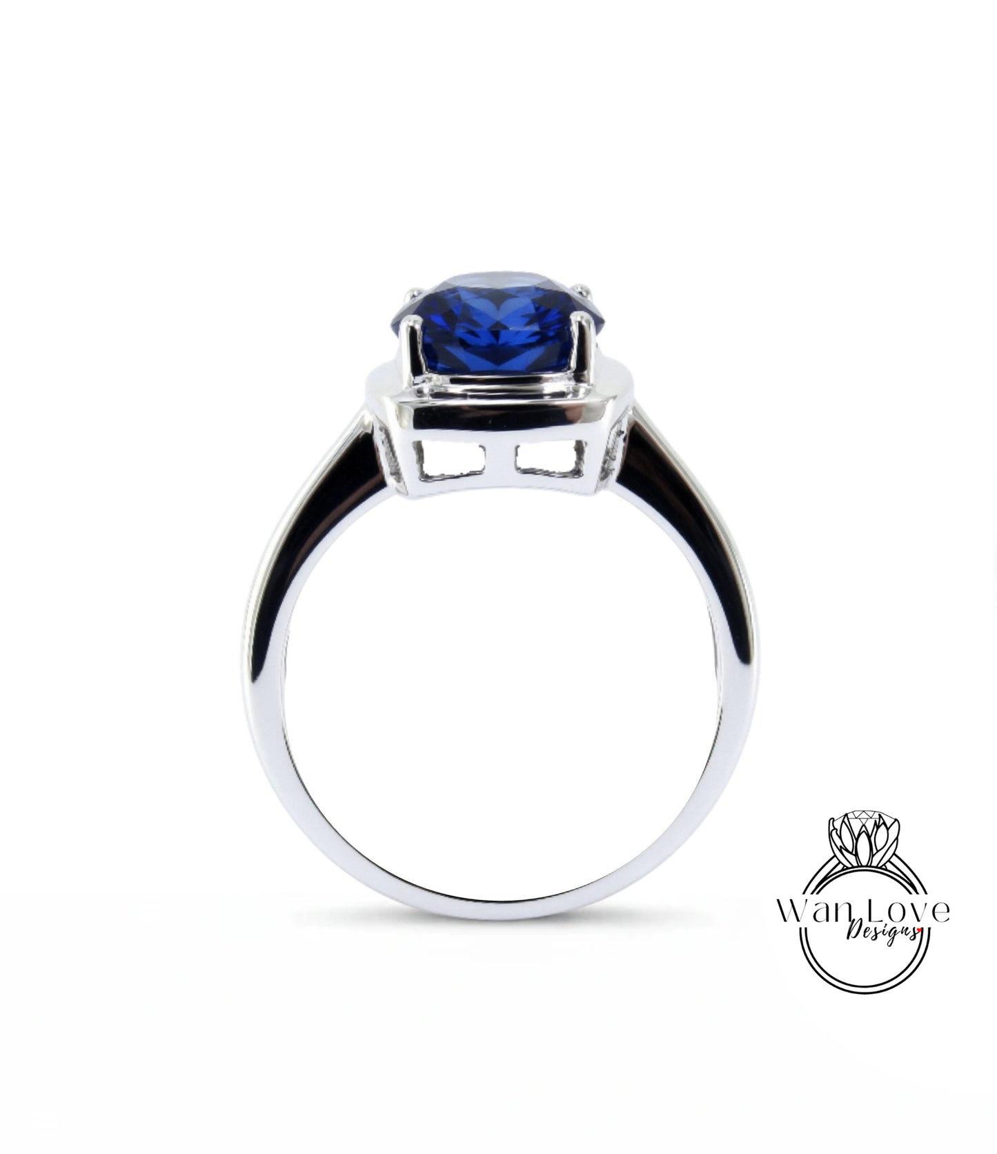 A silver ring with a large blue gemstone, likely a sapphire, set in the center.
