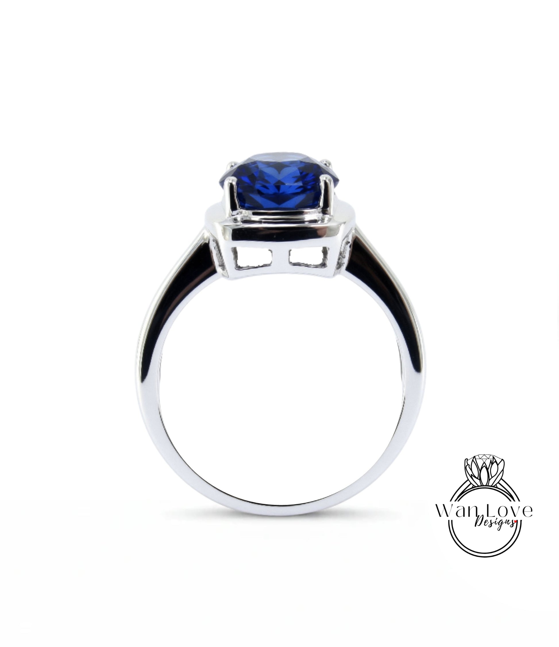 A silver ring with a large blue gemstone, likely a sapphire, set in the center.