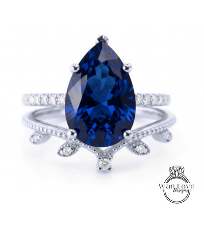 A close-up image of a silver ring with a large blue gemstone, likely a sapphire, set in a decorative band.