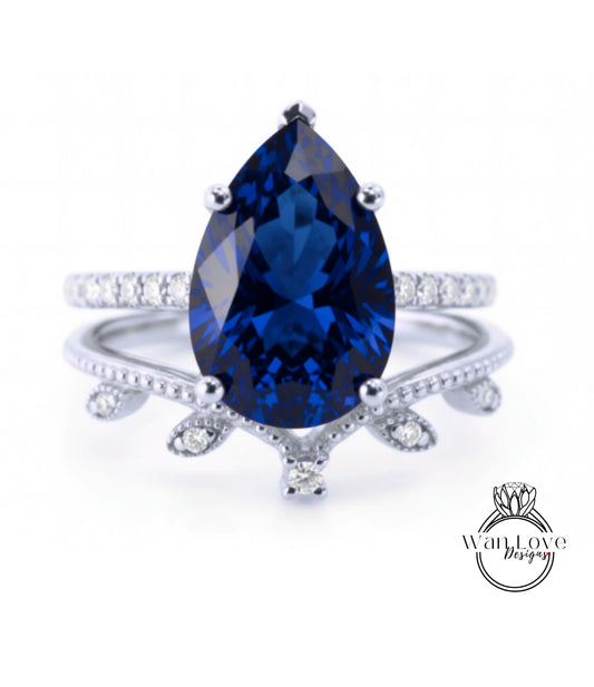 A close-up image of a silver ring with a large blue gemstone, likely a sapphire, set in a decorative band.
