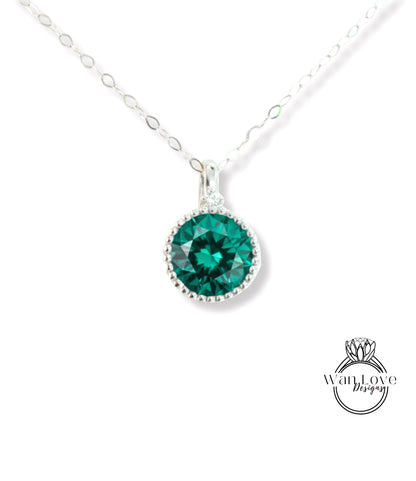 A silver necklace with a large, round green gemstone pendant.