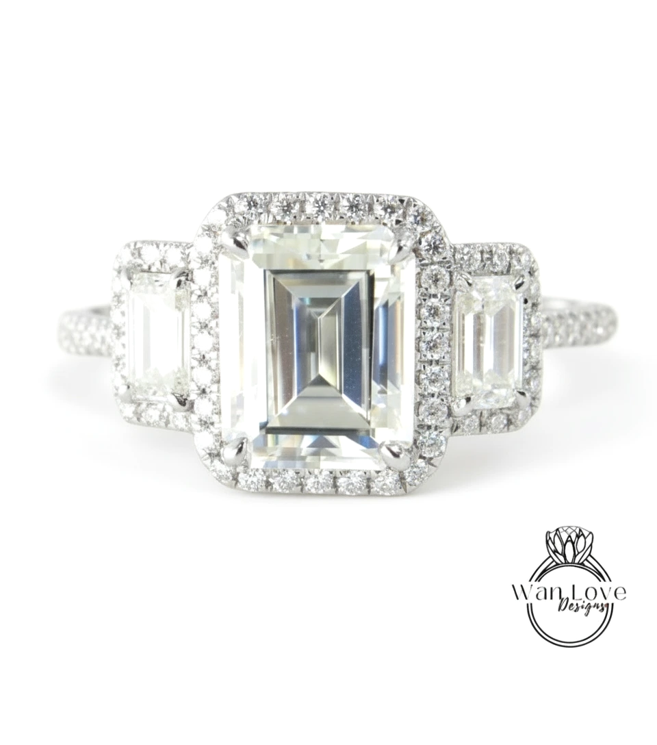 A close-up of a diamond engagement ring with a large central diamond surrounded by smaller diamonds on either side.