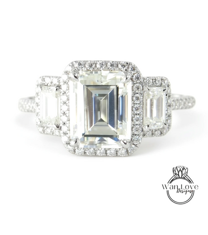 A close-up of a diamond engagement ring with a large central diamond surrounded by smaller diamonds on either side.