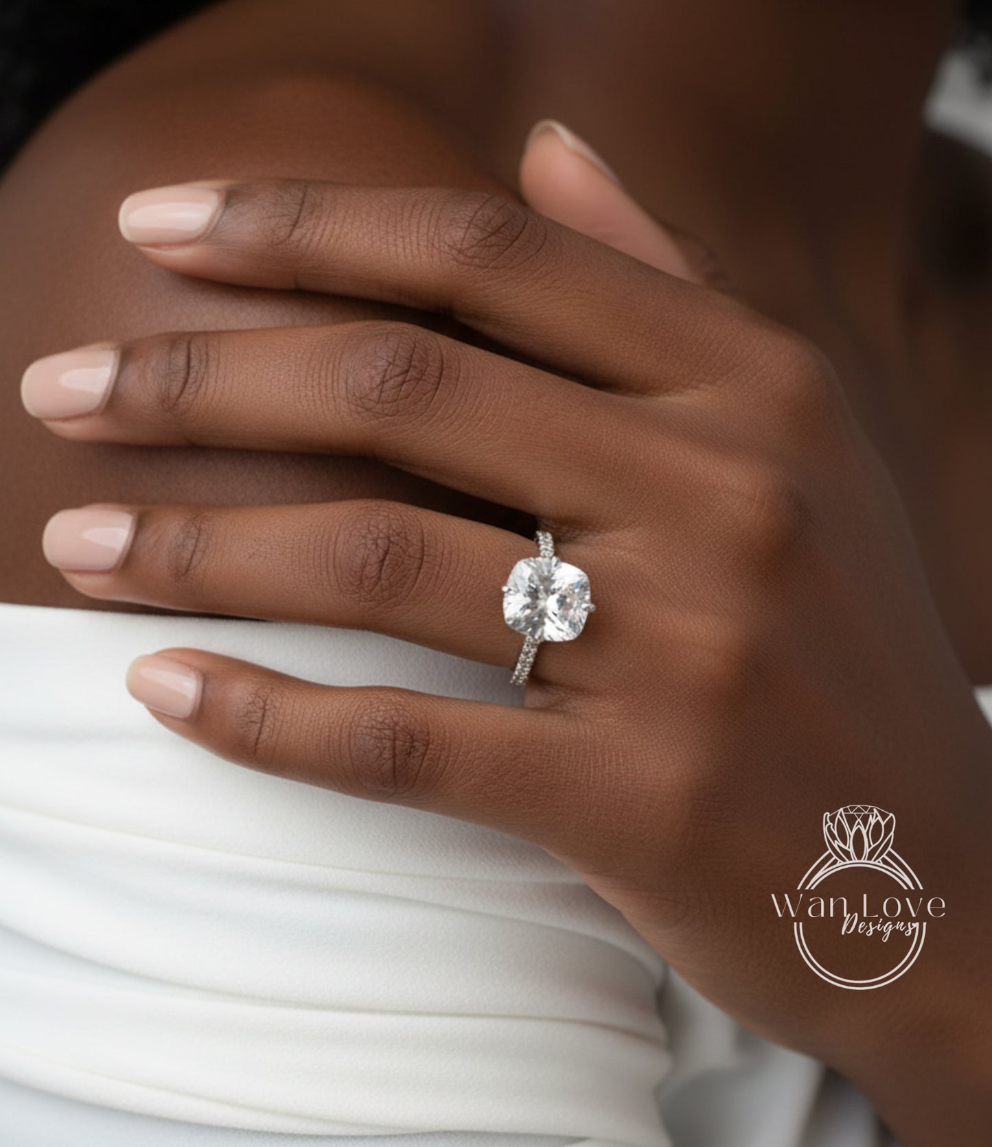 A close-up of a person's hand wearing a large diamond engagement ring.