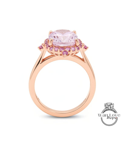 A rose gold ring with a large pink gemstone set in the center, surrounded by smaller pink gemstones.