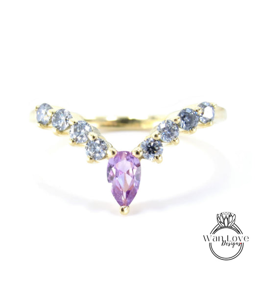A gold ring with a large purple gemstone in the center, surrounded by smaller blue gemstones.
