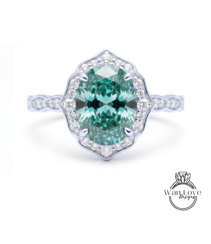 A stunning engagement ring with a large oval-shaped gemstone set in a halo of smaller diamonds, surrounded by a scalloped band.