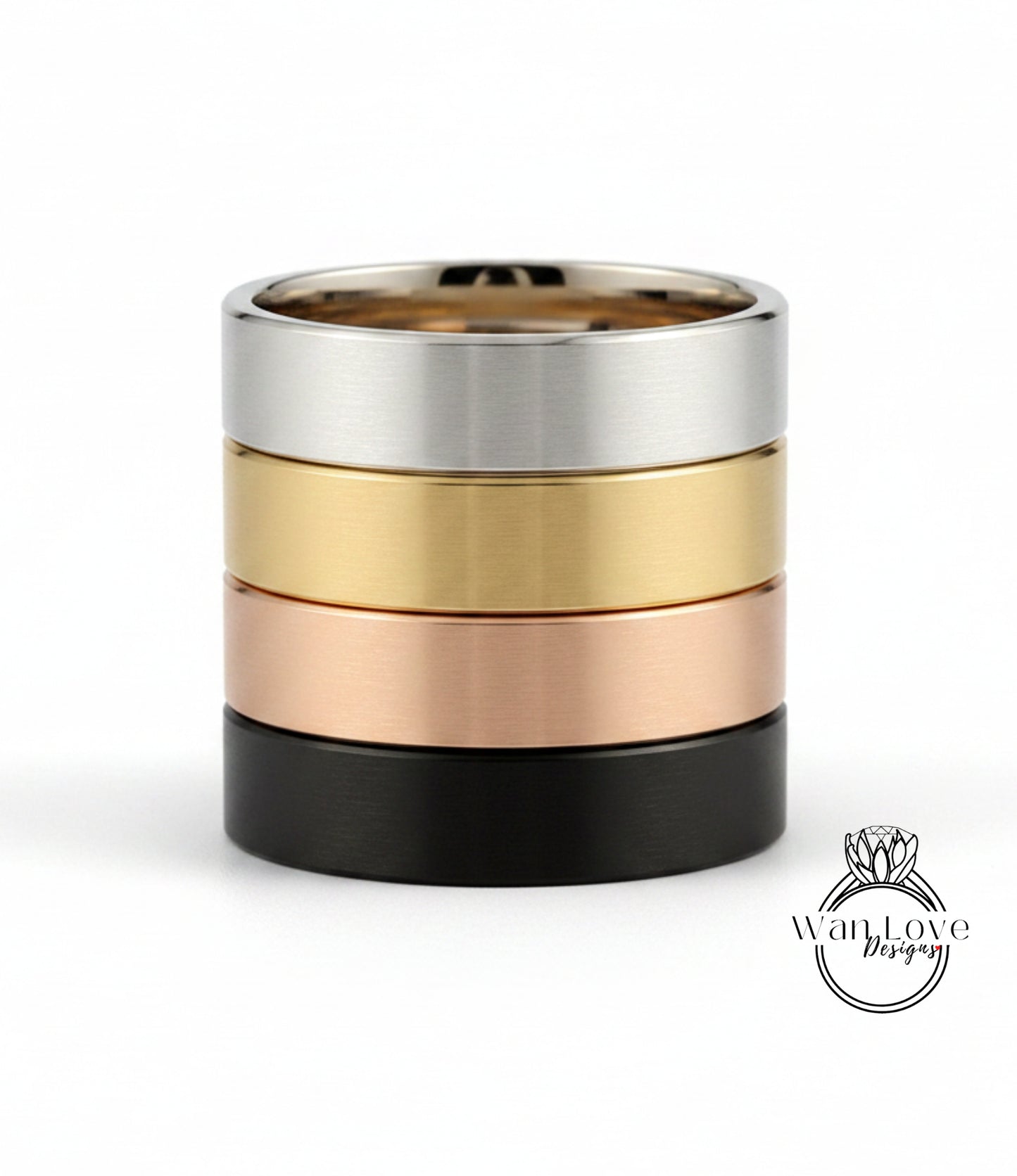 A stack of four rings in different colors: silver, gold, black, and copper.
