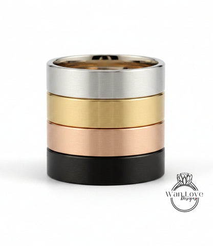 A stack of four rings in different colors: silver, gold, black, and copper.
