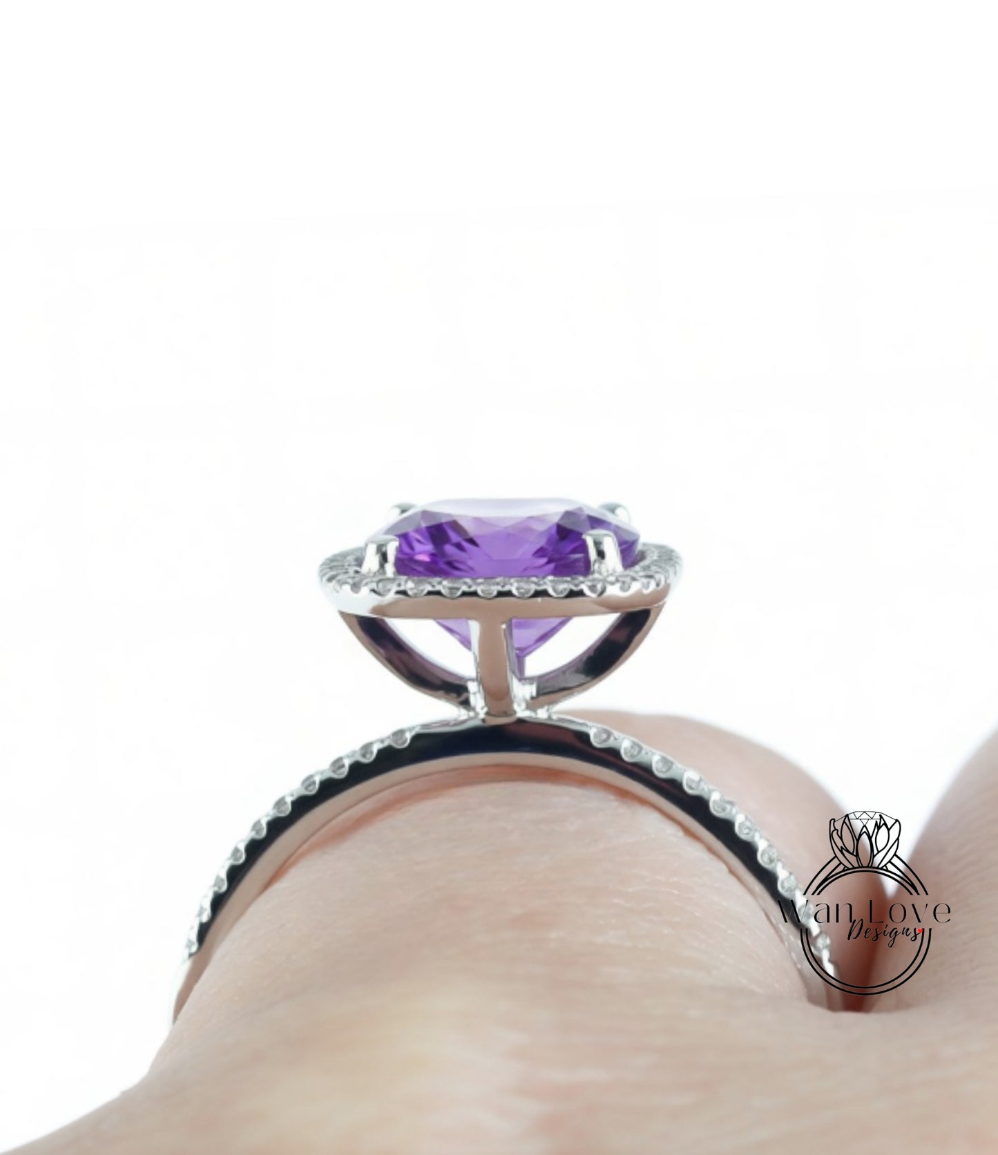 A close-up view of a silver ring with a large purple gemstone, likely an amethyst, set in a halo of smaller diamonds.
