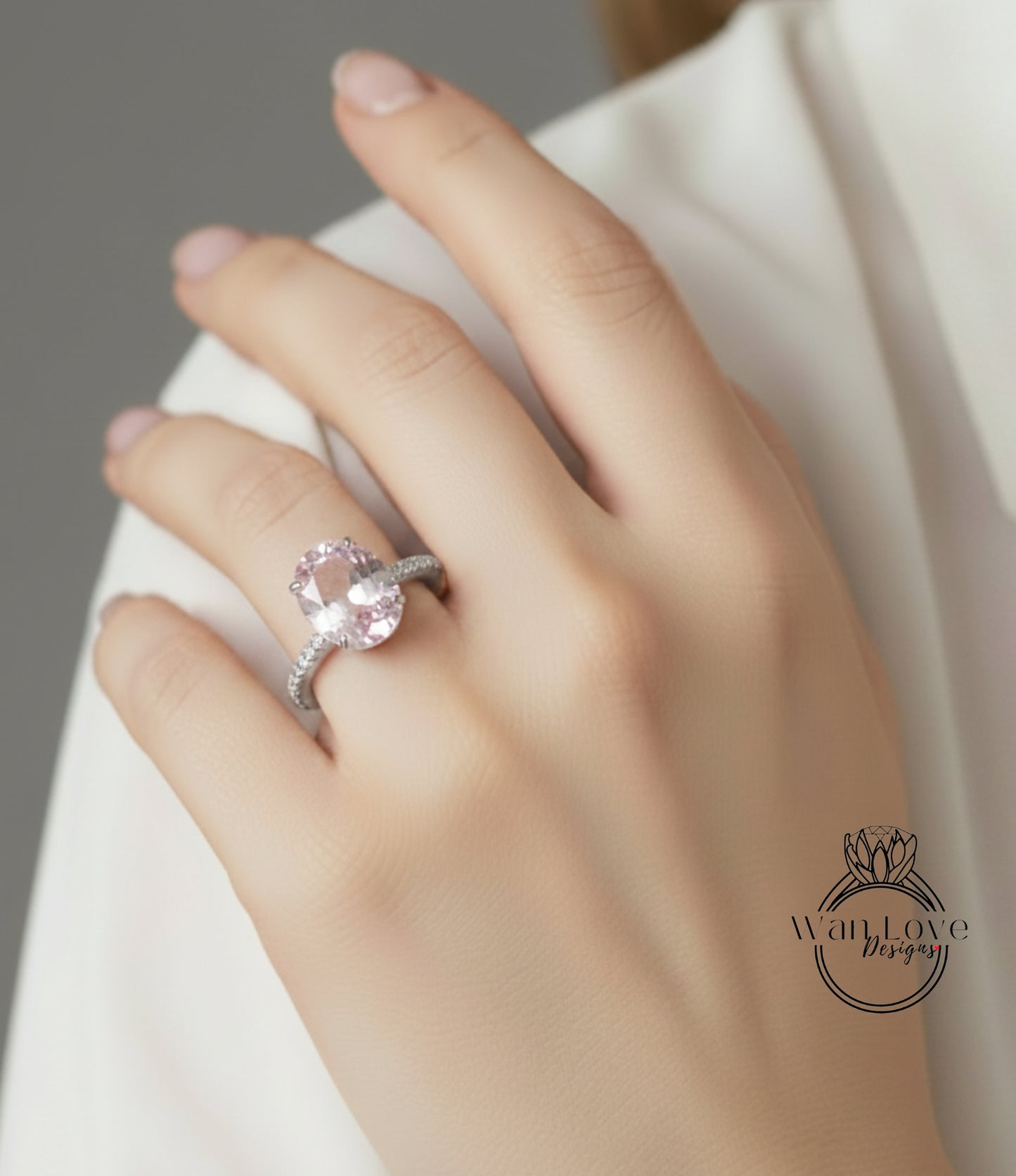 A close-up of a person's hand wearing a diamond engagement ring.