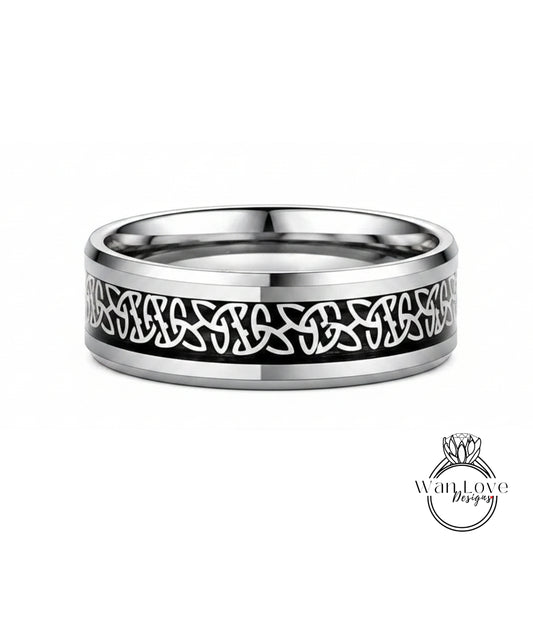 A silver ring with a black Celtic knot design on the band.