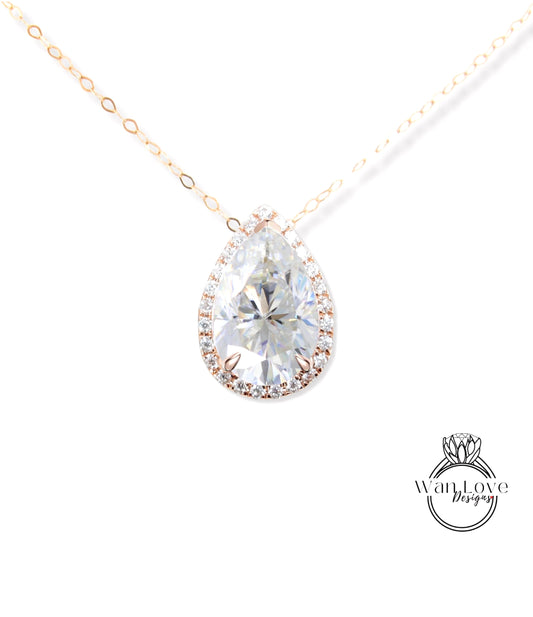 A close-up of a diamond pendant with a large, clear gemstone set in a halo of smaller diamonds, suspended from a gold chain.