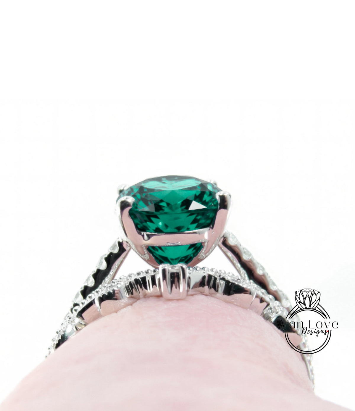 A close-up view of a silver ring with a large, vibrant green gemstone, showcasing the intricate design and craftsmanship of the piece.