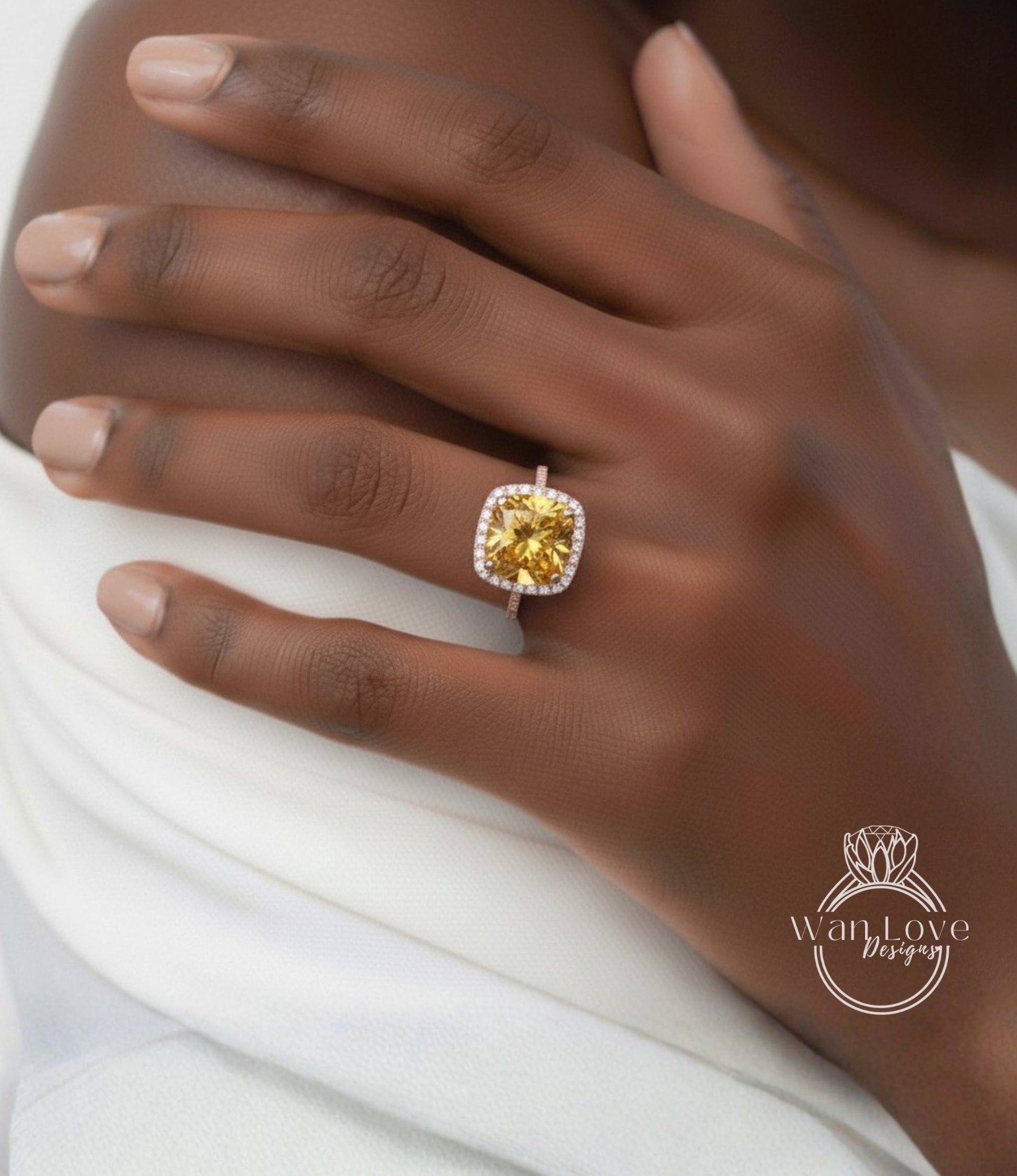 A close-up of a person's hand wearing a yellow diamond ring with a halo.