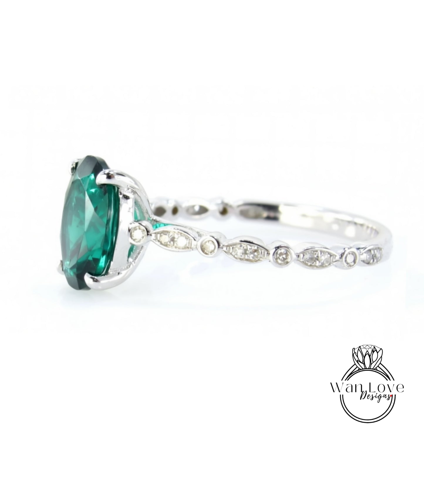 A close-up view of a silver ring with a large, vibrant green gemstone, possibly a diamond, set in the center.