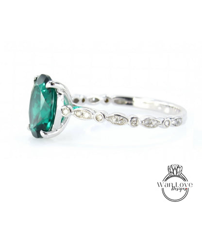 A close-up view of a silver ring with a large, vibrant green gemstone, possibly a diamond, set in the center.