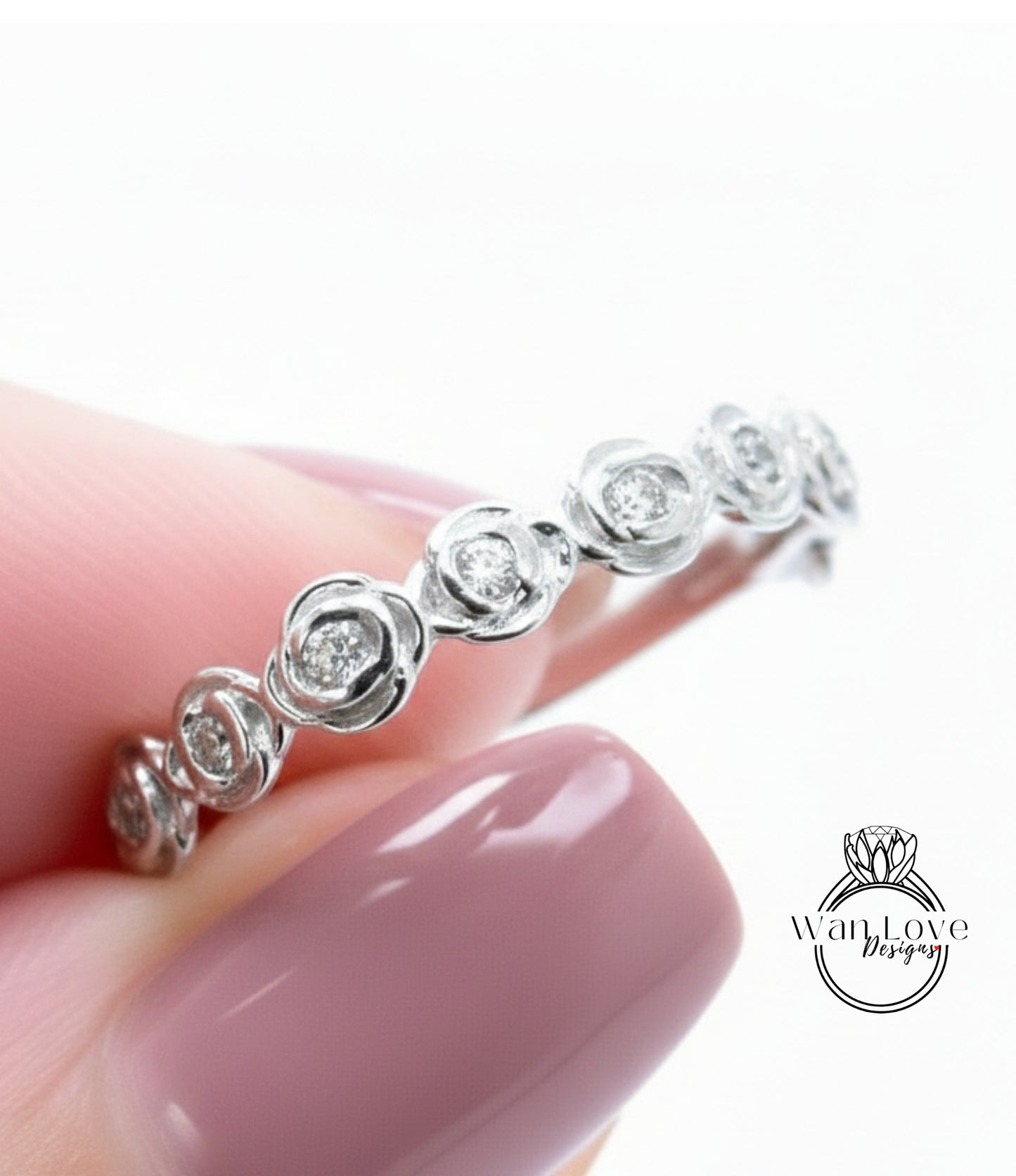 A close-up of a person's hand wearing a silver ring with a row of small diamonds on it.