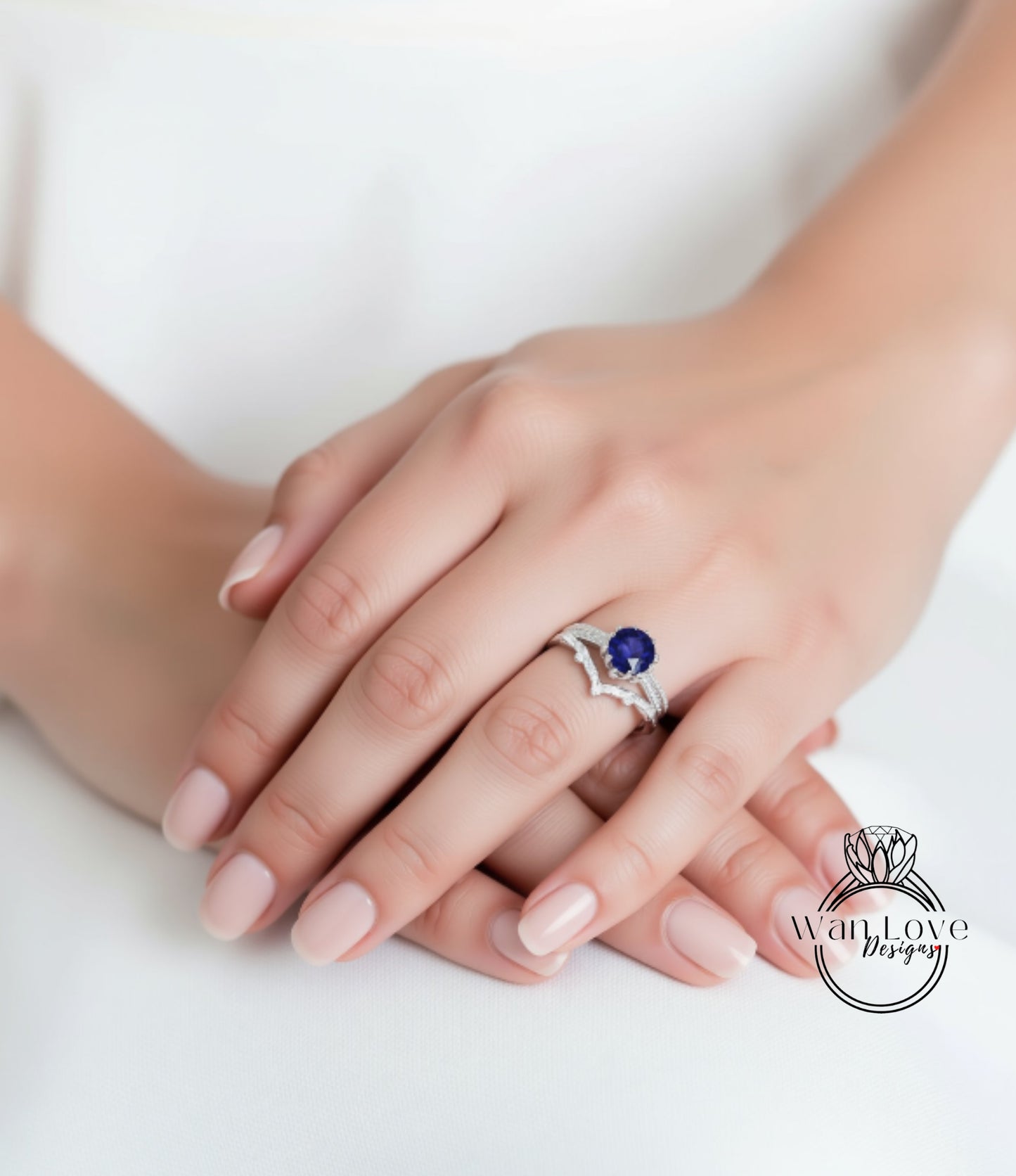 A close-up image of a person's hands wearing a ring with a blue gemstone.