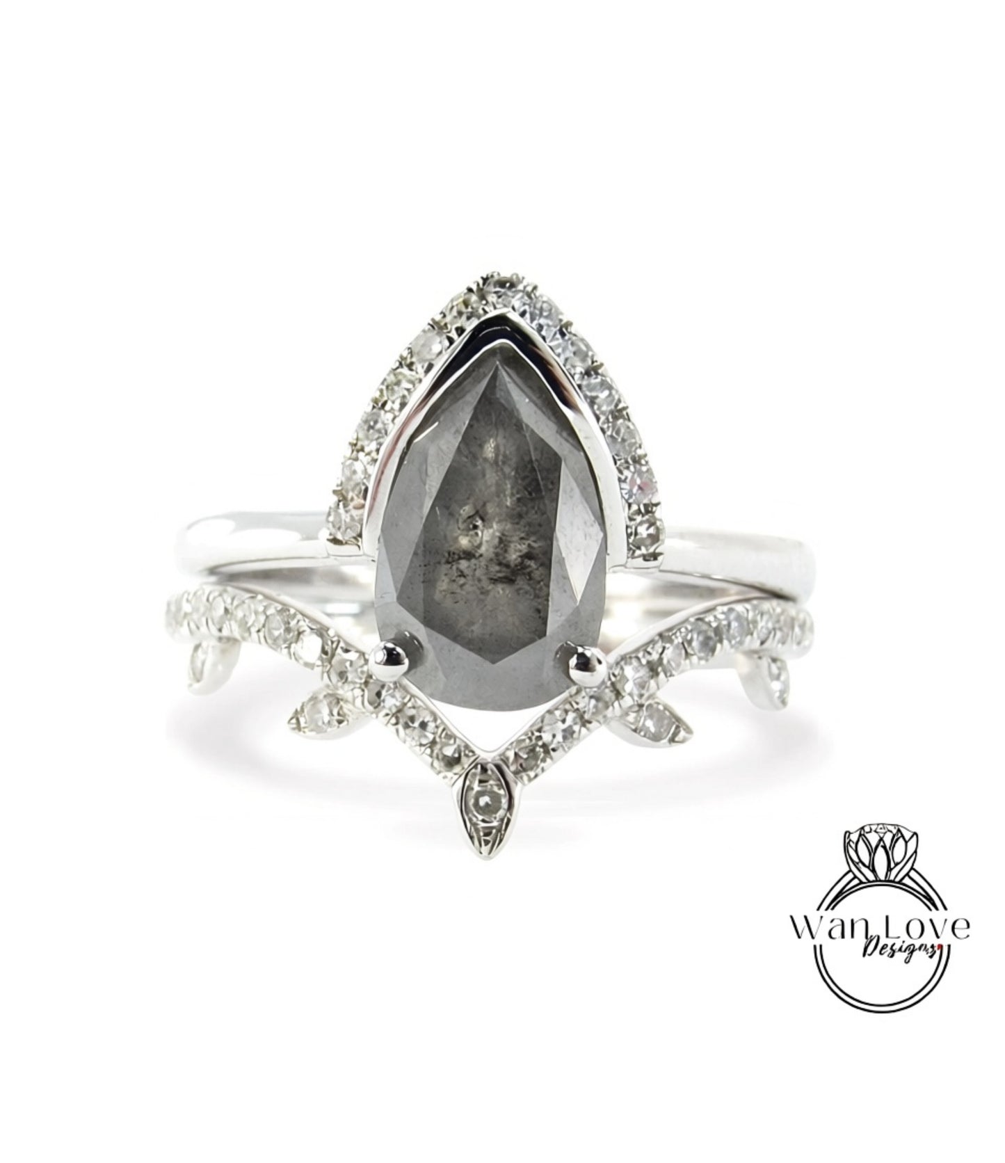 A silver ring with a large, dark gray diamond as the centerpiece, surrounded by smaller diamonds and a leaf-shaped accent.