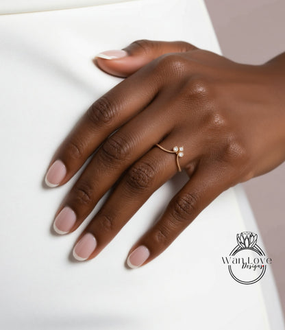 A close-up of a hand wearing a gold ring with a small flower design.