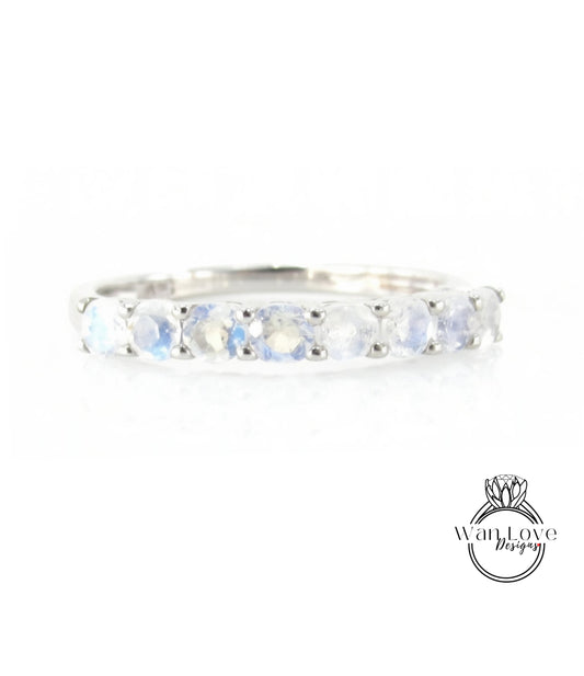 A silver ring with a row of blue moonstone stones set in a band.