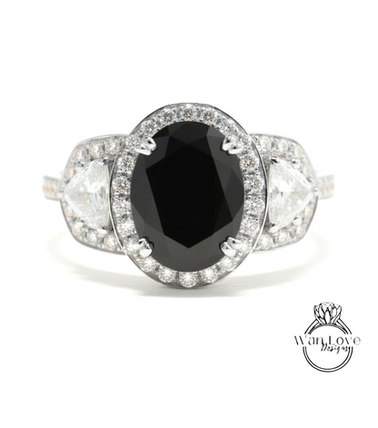 A close-up view of a diamond engagement ring with a large oval-shaped black gemstone surrounded by smaller diamonds.
