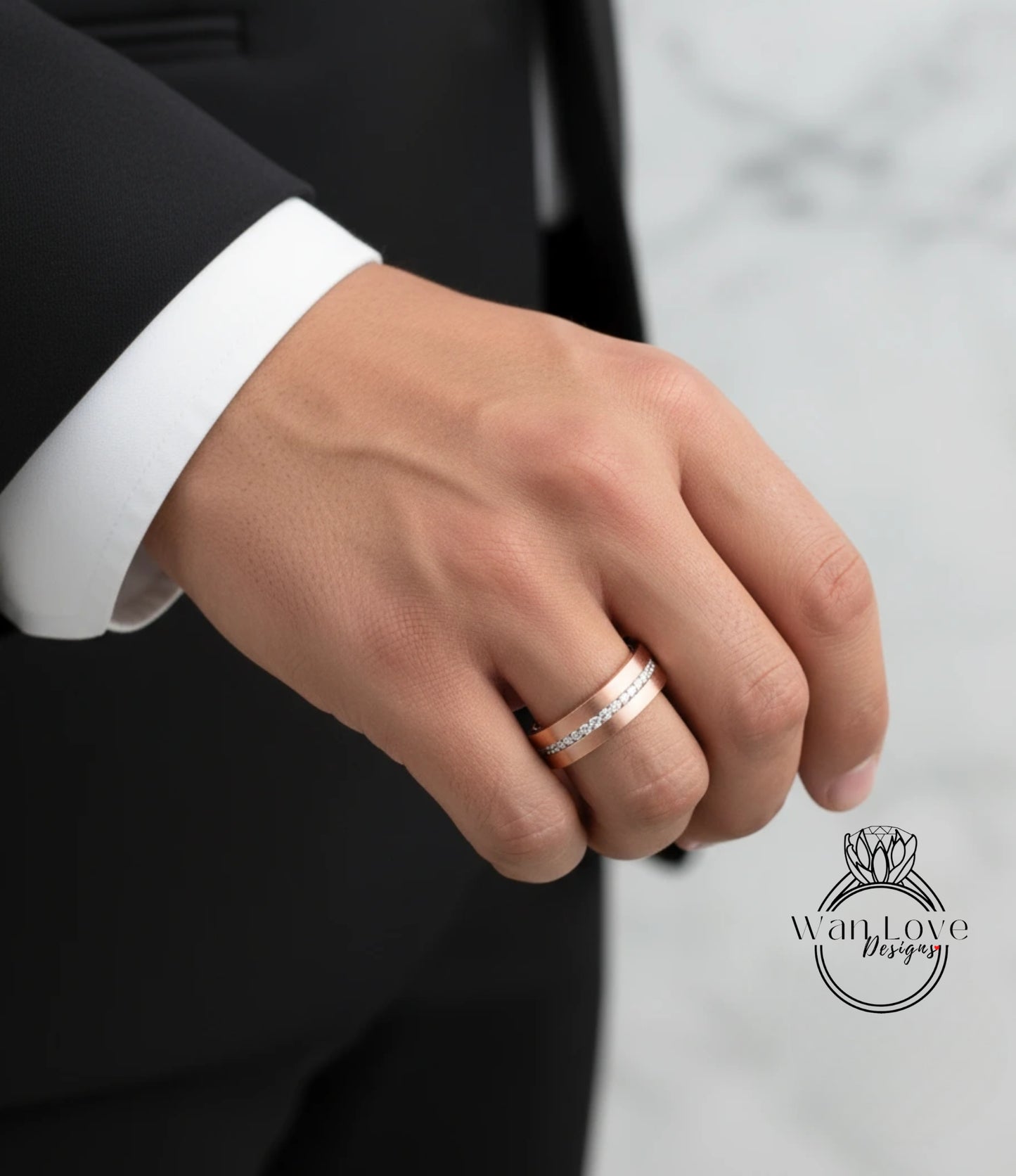 A close-up of a person's hand wearing a gold wedding band on the ring finger.