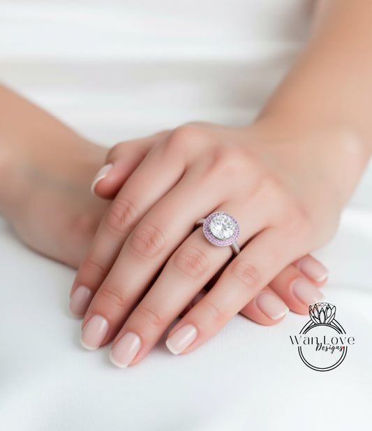 A close-up of a person's hand wearing a large, ornate ring with a large central stone surrounded by smaller stones.