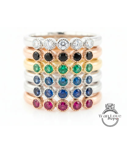 A stack of rings with various colored gemstones, including diamonds and gemstones, arranged in a visually appealing manner.