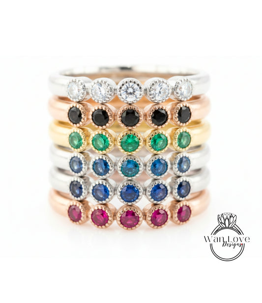 A stack of rings with various colored gemstones, including diamonds and gemstones, arranged in a visually appealing manner.